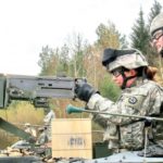 Army woman Master Sgt. Renee Baldwin fires machine gun at combat training, Germany