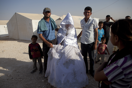Wedding family members and the groom (rt) with a 15-year-old Syrian refugee just after she left her family to travel to a nearby caravan in a refugee camp in Jordan, 5-4-13/Photo: Heidi Levine, Sipa Press