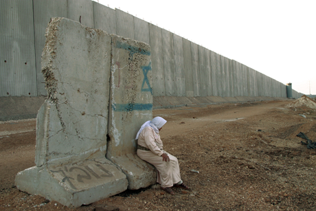 Palestinian woman rests on a cement barrier by the 1.8 mile long concrete wall along the northern West Bank, 10/11/02/Photo: Heidi Levine