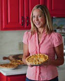 Beth M. Howard, "The Pie Lady" holding a pie in her kitchen