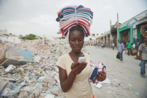Ketteline Pierre, high school student in Haiti with cellphone/Natasha Fillion/Bill & Melinda Gates FOundation